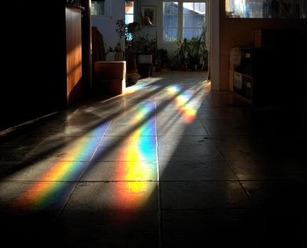 A rainbow of light shines through the window of a room photo