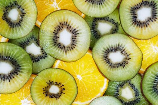 Circular kiwi slices overlap juicy orange segments creating abstract, colorful pattern background detail. photo