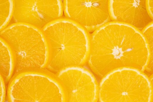Many thin orange slices are arranged edge to edge creating a full background texture of citrus. photo