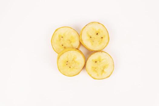 Four round banana slices are positioned in a square cluster showing internal fruit pattern on a white background. photo