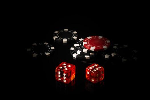 Dice and chips obtained from winnings while playing Craps. The idea of the game on a black background with space for advertising photo