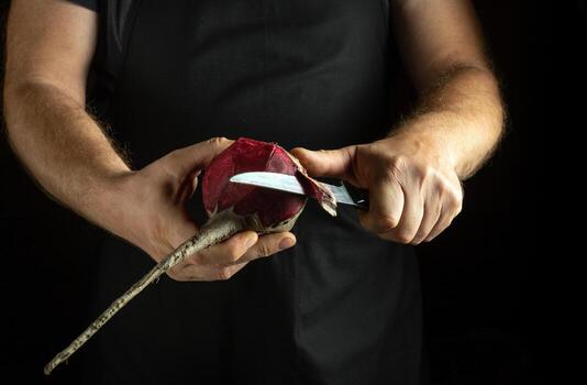 Hands skillfully peel a fresh beetroot using a sharp knife, emphasizing the vibrant color and texture of the vegetable. The atmosphere is warm and inviting, perfect for culinary creativity photo