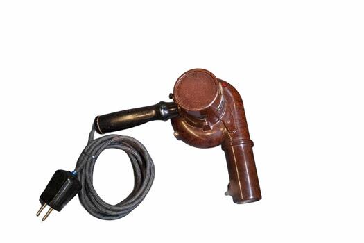 Vintage electric blower with a curved nozzle and power cord designed for small spaces and efficient air circulation photo