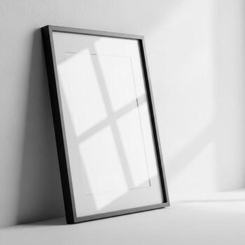 A sleek black framed empty picture frame leans against a textured wall isolated on white background photo