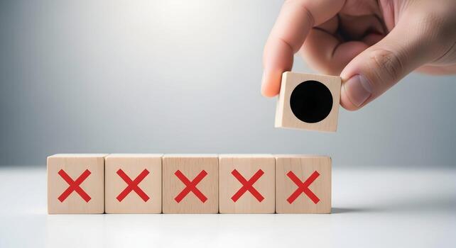 Hand placing a black circle block on wooden cubes with red crosses, signifying a correct choice or solution to a problem The concept represents decision making, problem solving, and finding the right photo
