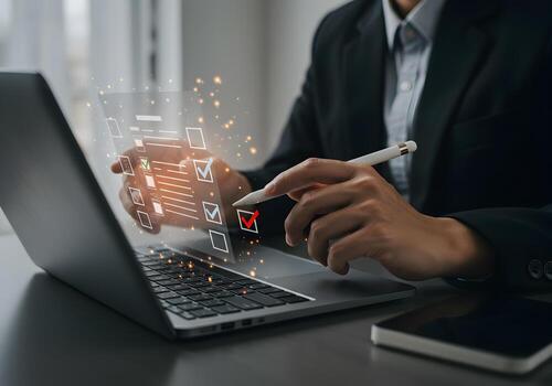 Businessperson using stylus on laptop to check tasks on a digital checklist interface in a modern office setting showcasing efficiency and productivity photo