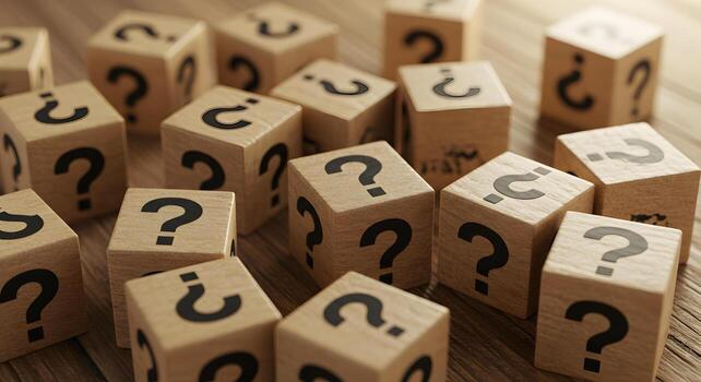Wooden Cubes with Question Marks Scattered on a Tabletop Representing Uncertainty and the Search for Answers photo