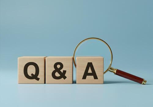 Wooden blocks spelling QA with a magnifying glass on a blue background symbolizing search for answers solutions and information photo