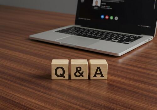 Wooden Blocks Spelling QA on Desk with Laptop Showing Online Meeting in Background - Questions Answers and Online Communication Concept photo