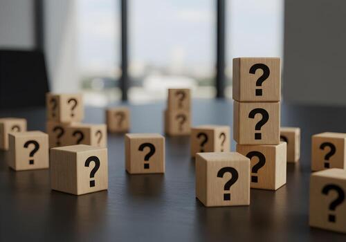 Wooden cubes with question marks stacked on a table in a modern office symbolizing uncertainty doubt questions and the search for answers photo