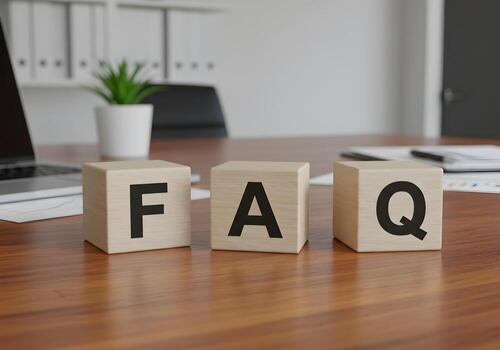 FAQ spelled out in wooden blocks on a modern office desk near a laptop suggesting answers to questions and solutions to problems The image evokes a sense of professionalism efficiency and readiness to photo