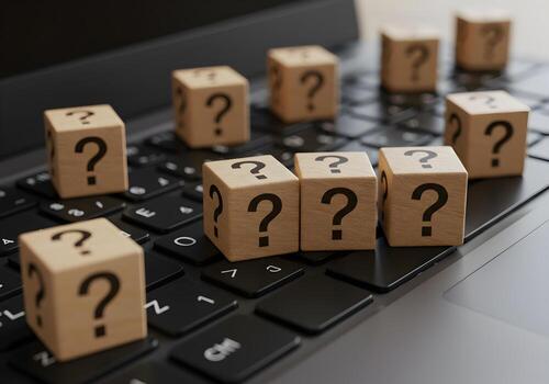 Wooden cubes with question marks on laptop keyboard uncertainty questions problemsolving and digital challenges concept photo