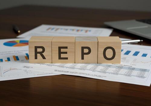 REPO Rate Spelled on Wooden Blocks on Financial Documents Showing Charts and Graphs on a Desk in an Office Setting Representing Financial Concepts and Market Analysis photo