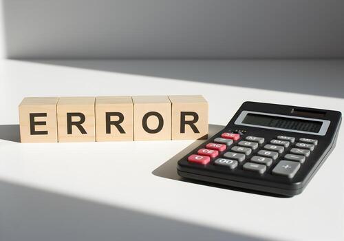Wooden blocks spelling ERROR next to a calculator on a white surface representing a calculation mistake financial error or accounting problem The image evokes feelings of frustration inaccuracy and th photo