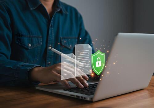Person secures digital documents using a laptop at a desk ensuring secure data protection and privacy in a modern office photo