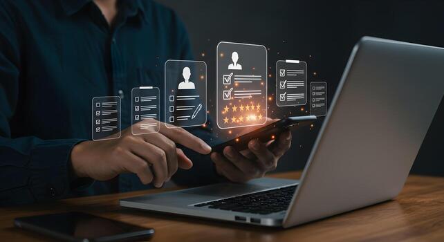 Person reviewing applications using a smartphone and laptop evaluating resumes and candidate profiles with a checklist and star rating in a modern office setting The image depicts a thorough and metic photo