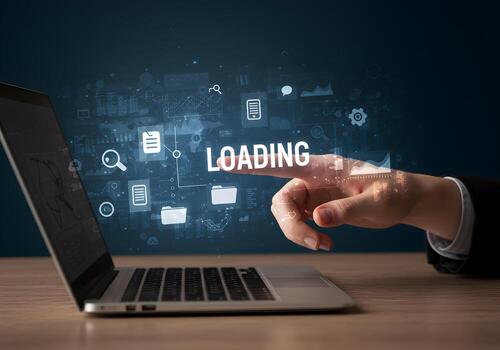 Hand interacting with a laptop screen displaying the word LOADING surrounded by digital icons and data representing the concept of progress and anticipation in a modern technological setting photo