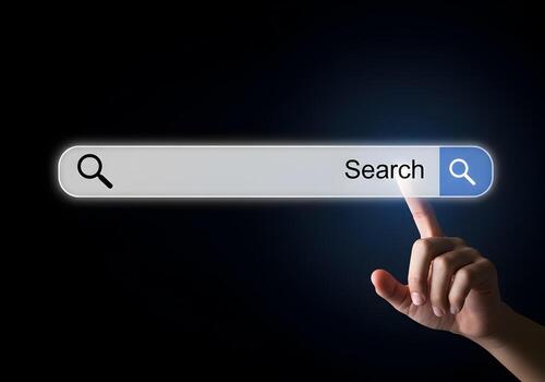 Closeup of a hand using index finger to touch search bar on a digital screen searching for information online The concept is finding information and exploring the internet The setting is dark and tech photo