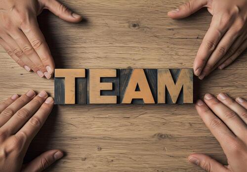 Teamwork concept Hands arranging letter blocks spelling TEAM on a rustic wooden surface symbolizing collaboration unity and support in achieving common goals photo
