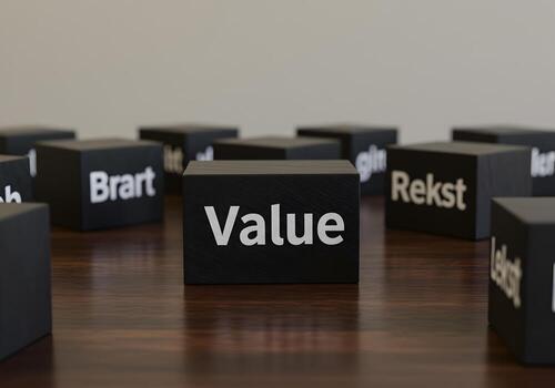Black cubes with the word Value standing out on a wooden surface signifying the importance of value among other concepts in business and finance photo