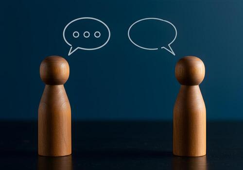 Wooden figures communicating via speech bubbles on a dark background symbolizing dialogue conversation and interpersonal communication photo