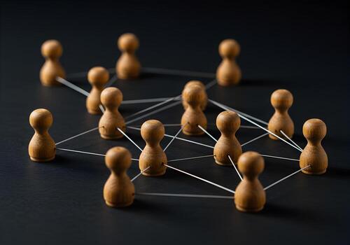 Wooden figures interconnected by strings on a dark background symbolizing networking connection and communication in business and teamwork photo