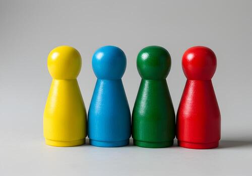 Four colorful wooden game pawns standing in a row on a neutral background representing diversity unity and teamwork in a playful setting This image is ideal for illustrating concepts related to collab photo