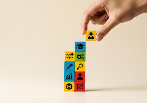 Hand placing a person icon block on top of a stack of colorful blocks representing education teamwork skills and career growth symbolizing talent acquisition and professional development photo