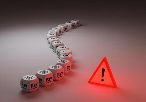 Financial Risk and Payment Warning A series of dice with the word Pay on them curve towards a red warning triangle symbolizing impending financial difficulties or payment issues The image represents c photo