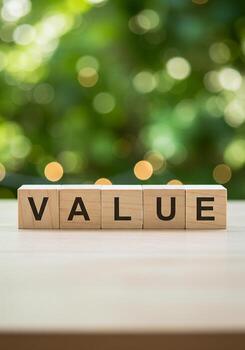 Wooden Blocks Spelling Value on Desk with Green Bokeh Background Concept of Importance Worth and Pricing photo