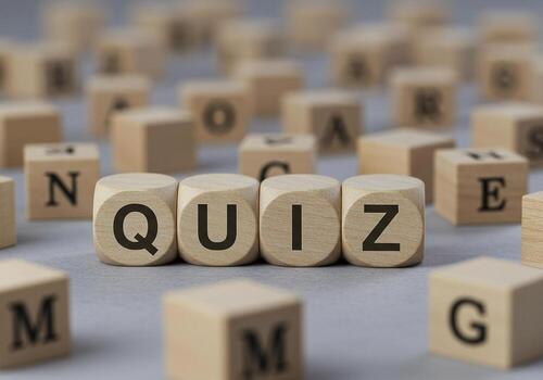 Quiz concept with wooden blocks spelling out QUIZ on a gray surface surrounded by other letter blocks representing a test examination or assessment This image evokes a sense of challenge education and photo