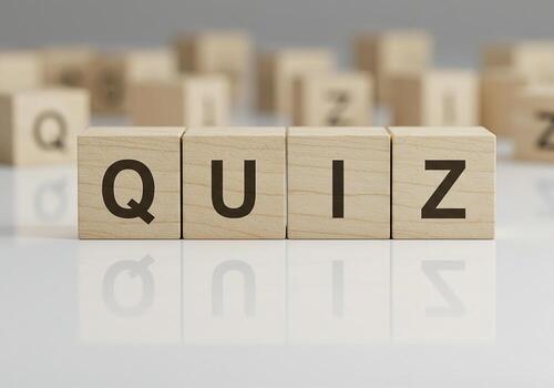 Quiz concept spelled out in wooden blocks on a reflective surface ideal for education testing and assessment themes The image evokes a sense of challenge and intellectual curiosity photo