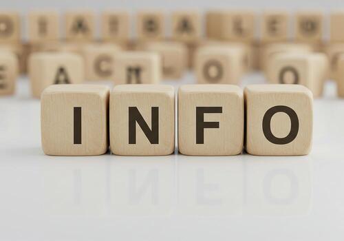 Wooden cubes spelling INFO on bright surface with blurred alphabet blocks in background conveying data information and knowledge concept photo