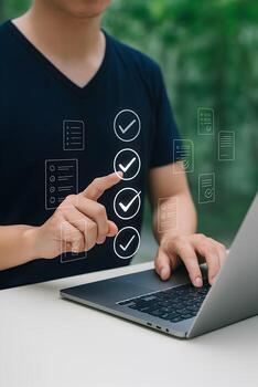 Man using laptop outdoors checking tasks on digital checklist completing project efficiently in nature success concept photo