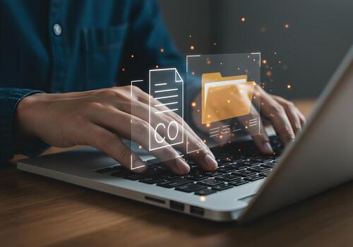 Person working on laptop computer managing digital files and documents with holographic interface in modern office concept of digital workspace and efficient workflow photo