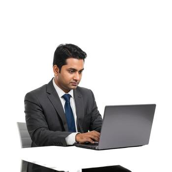 Man in suit working on a laptop at a desk in an office setting with a plain white background isolated photo