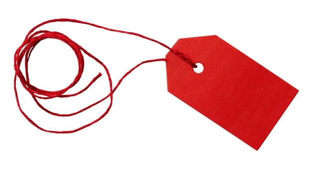 A bright red tag with string attached isolated on a white background in a studio setting close up view photo