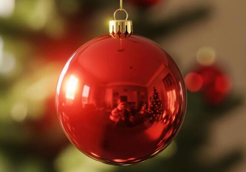Close up of a shiny red christmas ornament hanging on a tree photo