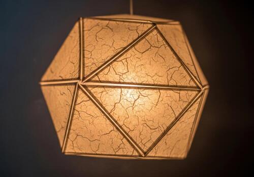 Geometric pendant light fixture with intricate patterned shade hanging indoors Origami Design photo