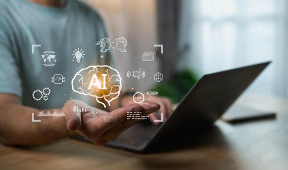 Person using laptop with hand holding virtual AI brain, showcasing technology, innovation, and digital transformation in modern workspace setting photo
