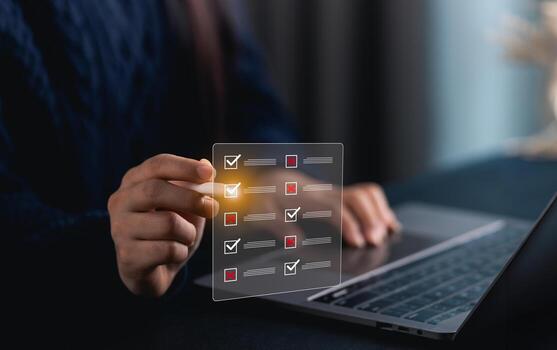 Close-up hand woman using digital checklist on laptop while managing tasks and projects for effective organization in modern workspace with ambient light photo