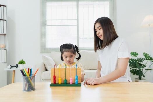 Child Learning with Abacus in Bright Room, Engaging Activities for Cognitive Development, Educator Assisting Young Learner at Home photo