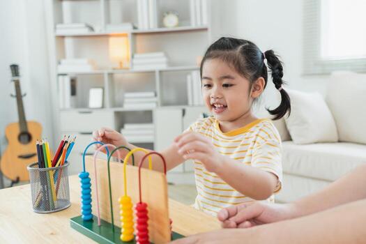 Happy child learning with colorful counting beads in bright, modern room, engaging in educational playtime, developing fine motor skills and creativity photo
