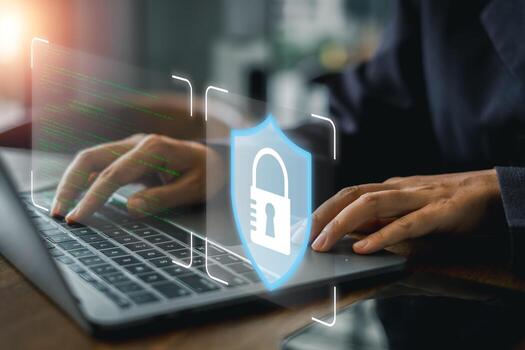 Hands typing on a laptop with a digital firewall icon, symbolizing cybersecurity and data protection. photo