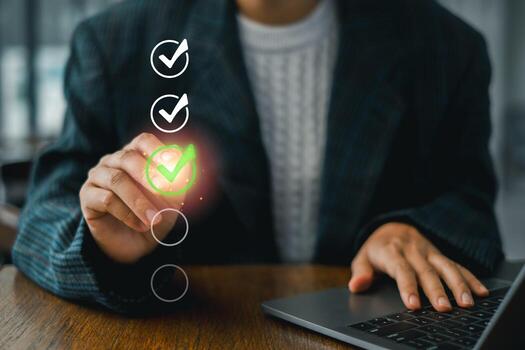 A business professional uses a digital checklist for assessment, highlighting a green check mark on a transparent screen interface. photo
