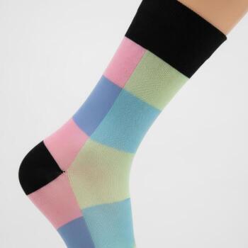 Close up of a single colorful patterned sock with pastel squares and black accents isolated on white background photo