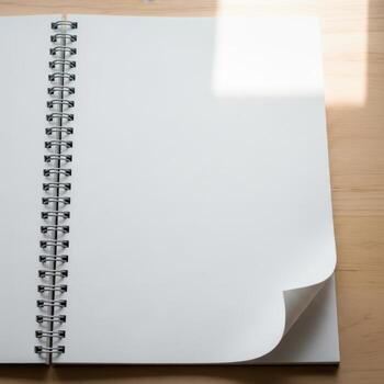 Open spiral bound notebook with blank pages and curved corner isolated on white background photo