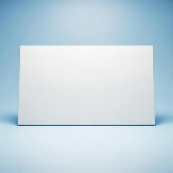 A blank white rectangular card or sign stands upright on a light blue surface isolated on white background photo