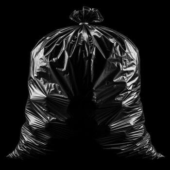 A full black garbage bag tied at the top presented isolated on white background photo