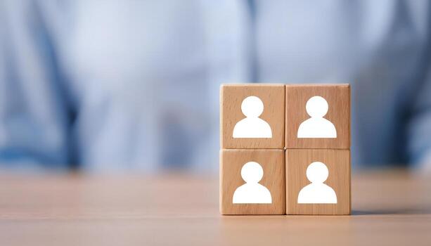 Four wooden blocks with person icons, representing teamwork or a group. photo